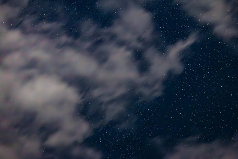 starry night sky with passing clouds