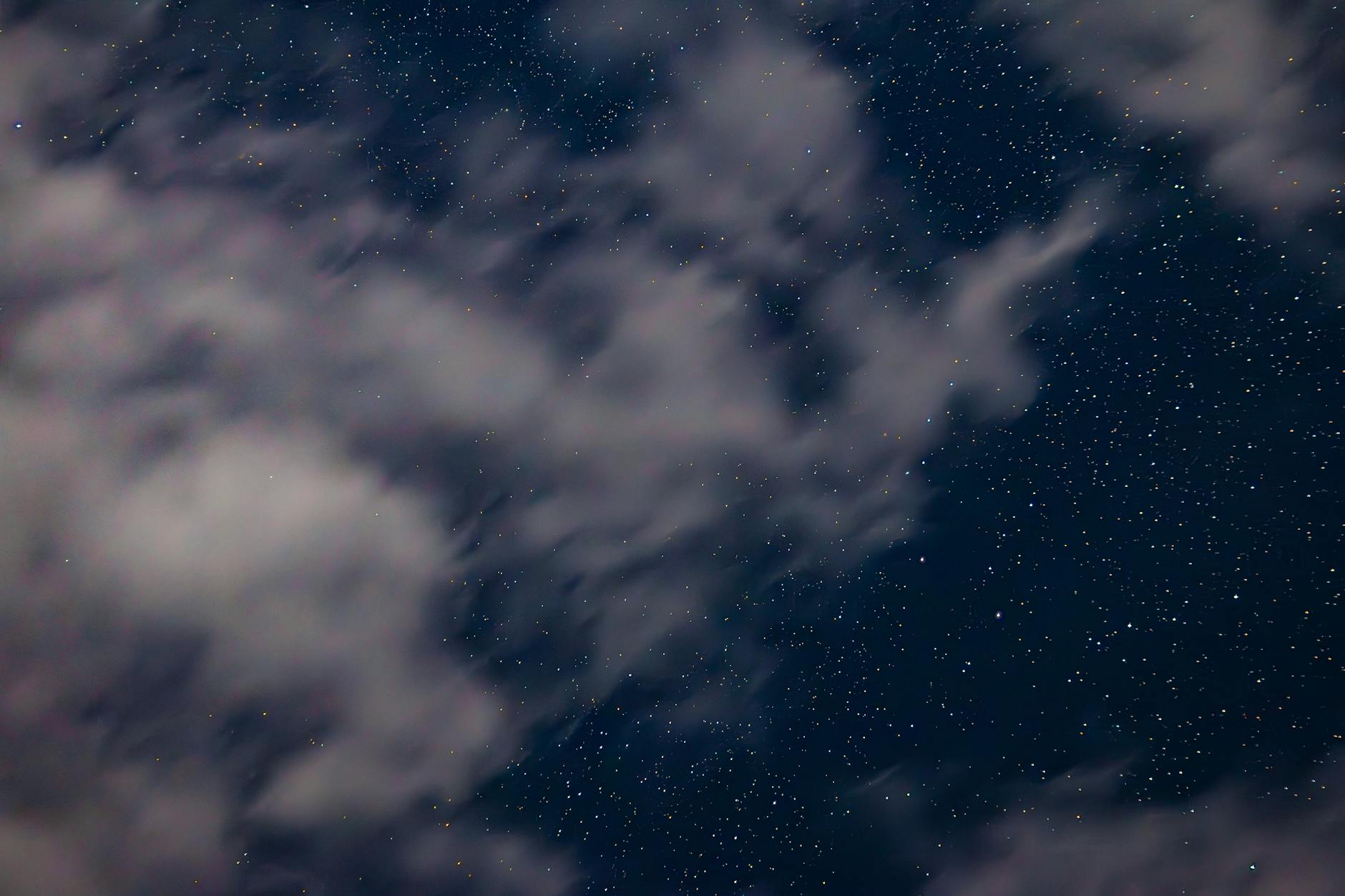starry night sky with passing clouds